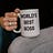 Hand of a woman in black holding white ceramic mug with the text “World’s Best Boss”.